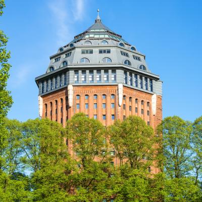 Wasserturm aus rotem Backstein mit achteckigem Spitzdach im Park